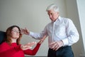 An elderly man hypnotizes a female patient. A woman in a session with a male hypnotherapist during a session. Therapist