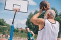 elderly men playing basketball together on playground Royalty Free Stock Photo