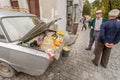 Elderly men selling homemade cheese from the counter in the trunk of vintage car