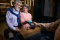 Elderly man and woman leaving hotel and paying their stay Royalty Free Stock Photo