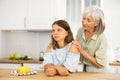 Elderly mother asks for forgiveness from her adult daughter and calms her down after a domestic quarrel in kitchen