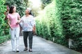 An elderly mother and daughter take a walk in the park happily