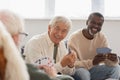 Elderly multiethnic men playing cards with Royalty Free Stock Photo