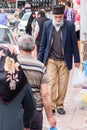 An elderly Muslim man with a gray beard walks after an evening Friday prayer.