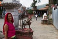 Elderly Nepali woman and temple, Pokhara, Nepal