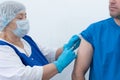 elderly nurse gives injection vaccinatio