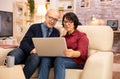 Elderly old couple using modern laptop to chat with their grandson