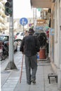 An elderly old man in a black shirt hat and walking with a cane on the street of the Greek city of Kavala. Greece, Kavala -