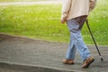 Elderly old man with walking stick stand waiting on footpath sidewalk crossing the street alone.