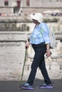 Elderly old turist woman walking with stick in Rome (Italy)