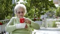 elderly old woman with brokenn hand drinking coffee Royalty Free Stock Photo