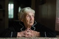 Elderly old woman looks sadly out the window. Royalty Free Stock Photo