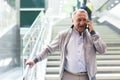 Elderly passenger talking on mobile phone at an underground metro station