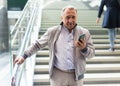 Elderly passenger talking on mobile phone at an underground metro station