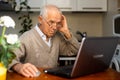 desperate old man pensioner chatting online via laptop with friends at home