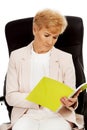 Elderly pensive focused business woman reading notes