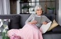 Elderly pensive lady relaxing on couch with book Royalty Free Stock Photo