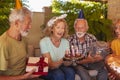 Elderly people blowing out candles on birthday cake Royalty Free Stock Photo