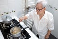 Elderly people cooking vegetables soup or stock in a saucepan and heating the ingredients,healthy food,good cook,asian senior Royalty Free Stock Photo