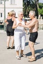 Elderly people dance and enjoy life outside on the waterfront of the island.