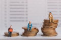 Elderly people figure sitting on stack of silver coins on bank passbook. Royalty Free Stock Photo