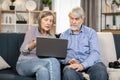 Elderly people with laptop enjoying spare time at home Royalty Free Stock Photo