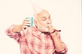 Elderly people. Man bearded grandpa with birthday cap and drink cup. Birthday crazy party. Ideas seniors birthday Royalty Free Stock Photo