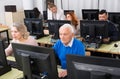 Elderly people working on computers with young teacher Royalty Free Stock Photo