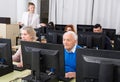 Elderly people working on computers with young teacher Royalty Free Stock Photo
