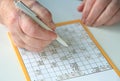 Elderly person doing crossword puzzle