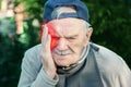 Elderly person suffers from headaches, hypertension, stress, or migraines. sick old man suffers from headache, migraines with red Royalty Free Stock Photo