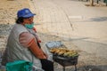 An elderly poor woman sells fried corn on the street of the capital of Albania - Tirana