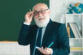 Elderly professor, teacher on a blank chalkboard during lesson. Senior professor, teacher teaching class at college Royalty Free Stock Photo