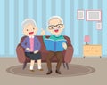 Elderly reading book together on sofa Royalty Free Stock Photo