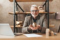 An elderly realtor holds the figure of a house in his hands and smiles. House purchase advice, experienced real estate agent