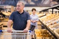 Elderly retired man buying bread and pastries in grocery section of the supermarket Royalty Free Stock Photo