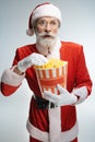 Elderly Santa Claus holding popcorn bucket in hands