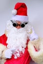 Elderly santa claus in a suit, with a white beard congratulates children and adults, shows with his hands, the concept of