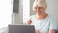 Elderly senior blond woman working on laptop computer at home. Received good news excited and happy Royalty Free Stock Photo