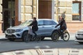 Elderly Senior Couple Cycling on road in the centre of the city during sunny day