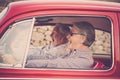 Elderly senior couple with hat, with glasses, with gray and white hair, with casual shirt, on vintage red car on vacation enjoying Royalty Free Stock Photo