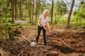 Senior elderly gardener woman digging caring ground level at summer farm countryside outdoors using garden tools rake Royalty Free Stock Photo