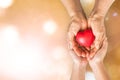 Elderly senior person or grandparent's hands with red heart in support of nursing family caregiver Royalty Free Stock Photo