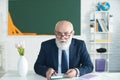 Elderly Senior professor reading an old book in the library, knowledge, learning and education concept. Royalty Free Stock Photo