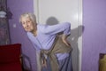 Elderly senior 75s woman with painful feelings in lumbar, massaging low back to reduce ache, suffer from backache discomfort