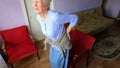 Elderly senior 75s woman with painful feelings in lumbar, massaging low back to reduce ache, suffer from backache