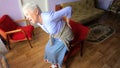 Elderly senior 75s woman with painful feelings in lumbar, massaging low back to reduce ache, suffer from backache