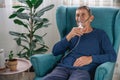 Elderly senior sits in a armchair with an oxygen mask in quarant Royalty Free Stock Photo