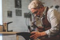 An elderly shoemaker in uniform at work