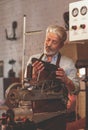 An elderly shoemaker at work